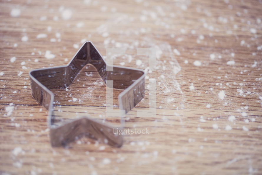 flour on a table and a star cookie cutter