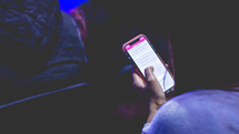 a person reading a Bible app on their phones  during a worship service 