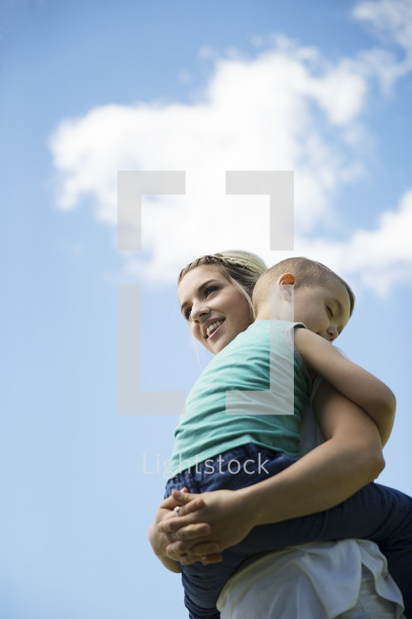 a mother and son hugging outdoors 
