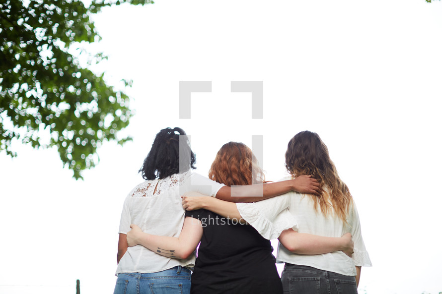woman standing with arms around each other 