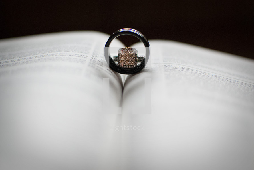 wedding rings between the pages of a Bible 