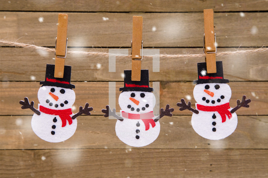snowman cutouts hanging by clothespins 