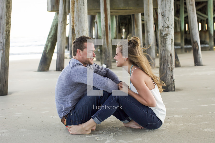a couple sitting on a beach talking 
