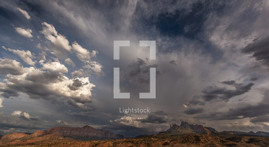 clouds over red rock peaks 