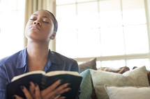 woman holding a Bible and looking up to God in prayer