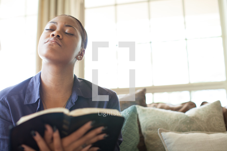 woman holding a Bible and looking up to God in prayer