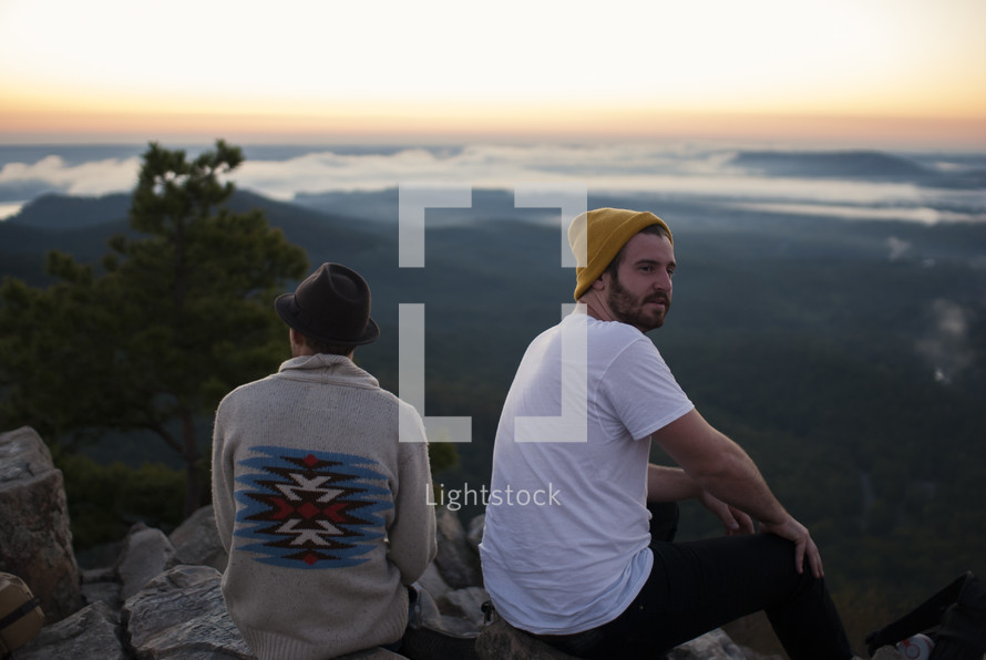 friends sitting on top of a mountain 