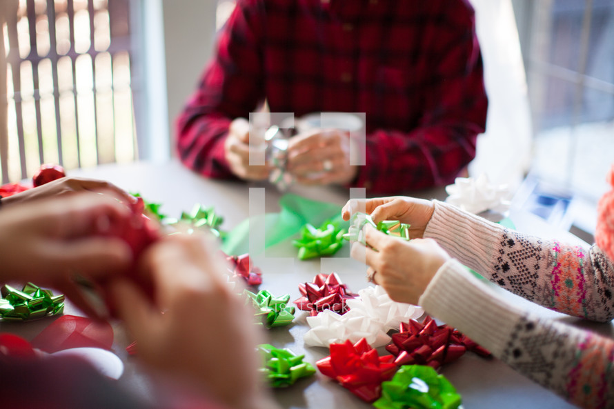 People wrapping Christmas presents around a table