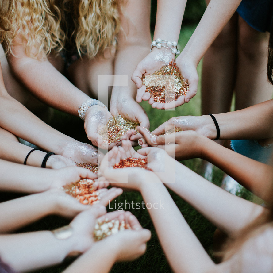 group of teen girls with glitter in their hands 