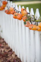 pumpkin lights on a fence 