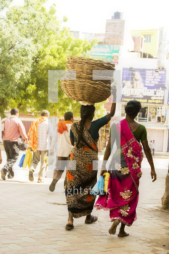 Woman in India carrying baskets on her head. 