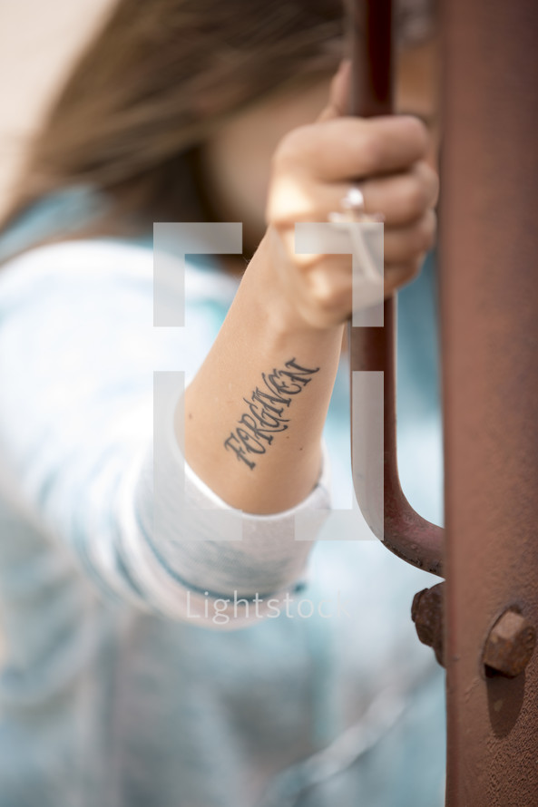 forgiven tattoo on a woman's arm
