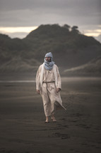 biblical figure walking on a beach 