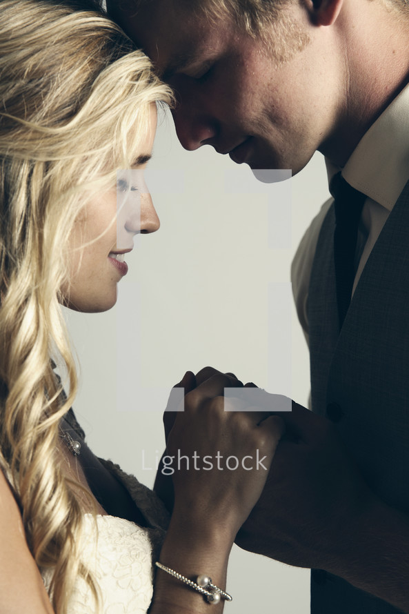 portrait of a bride and groom praying together. 