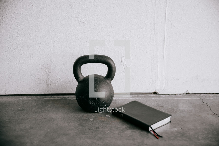 free weights at a gym and a Bible 