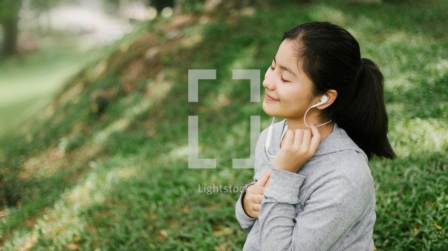 young woman listening to earbuds 