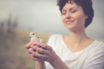 Smiling woman holding a dove.