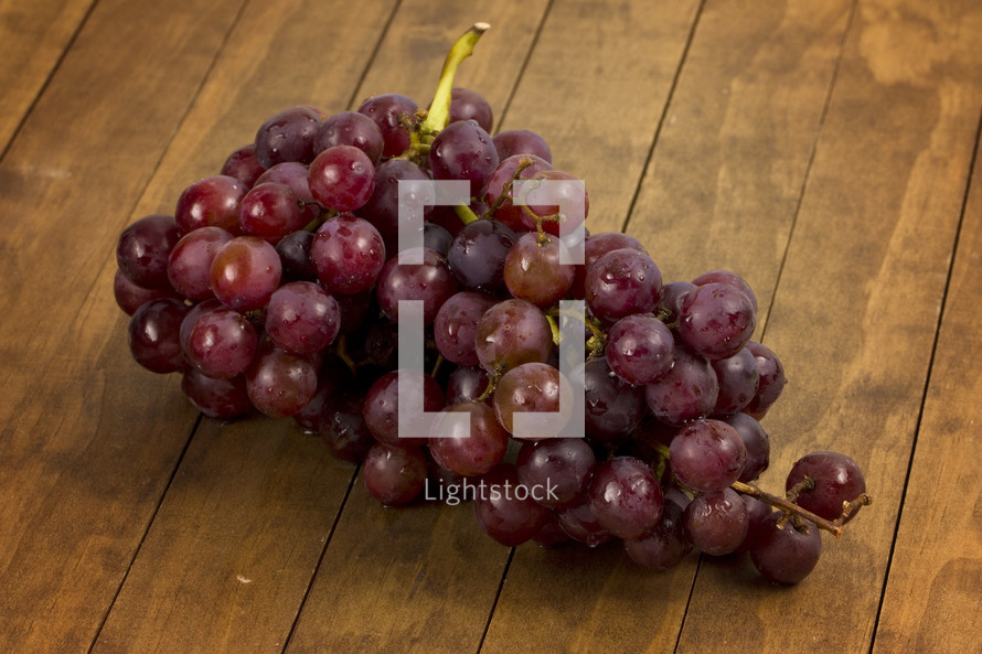 A cluster of grapes on a wooden table