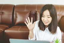 woman raising her hand while on a video conference call 