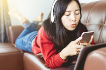 teen girl texting on a couch 