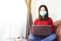 woman working from home wearing a mask 