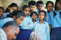 school children gathered around listening 