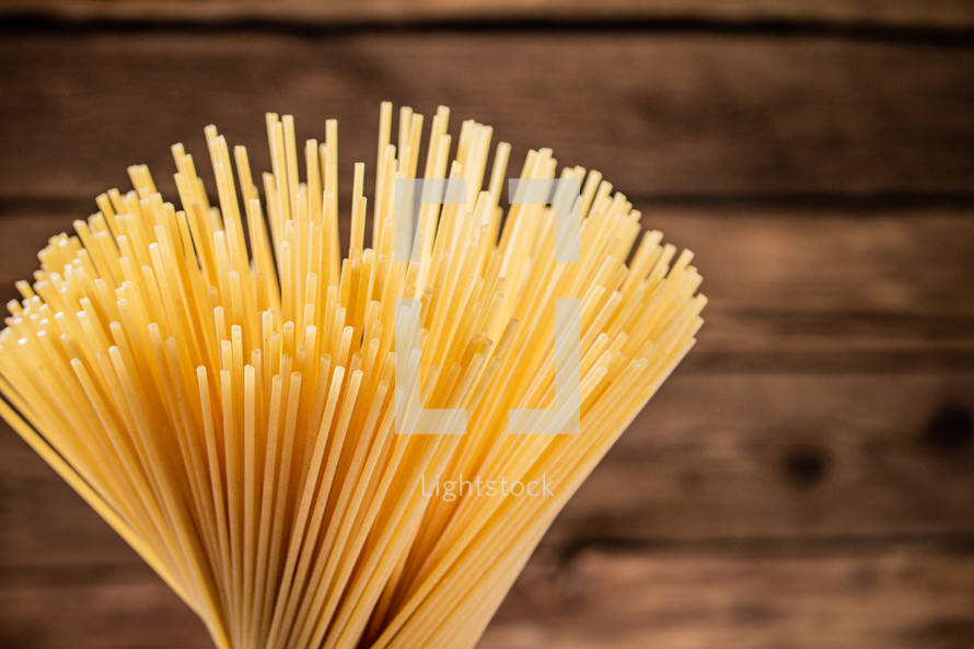 A pile of spaghetti dry on the table. Against a dark background. High quality photo