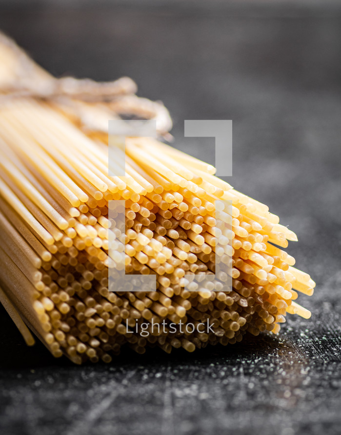 A pile of spaghetti dry on the table. Against a dark background. High quality photo