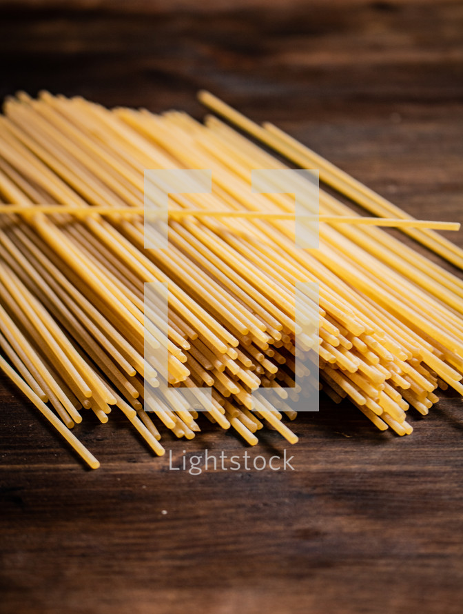 A pile of spaghetti dry on the table. Against a dark background. High quality photo