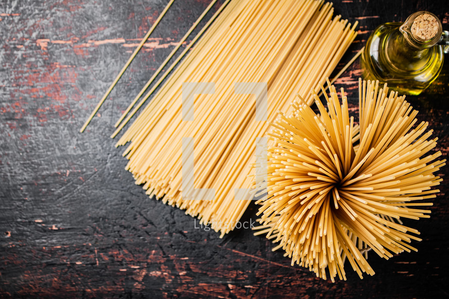 A pile of spaghetti dry on the table. Against a dark background. High quality photo