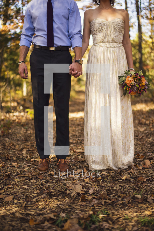 portrait of a bride and groom holding hands 