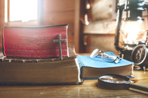 reading glasses and magnifying glass on a stack of Bibles 