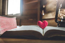 red felt heart on the pages of a Bible 
