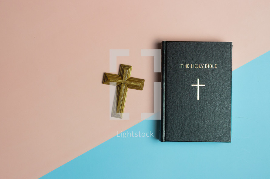 Bible and cross on a blue and pink background 