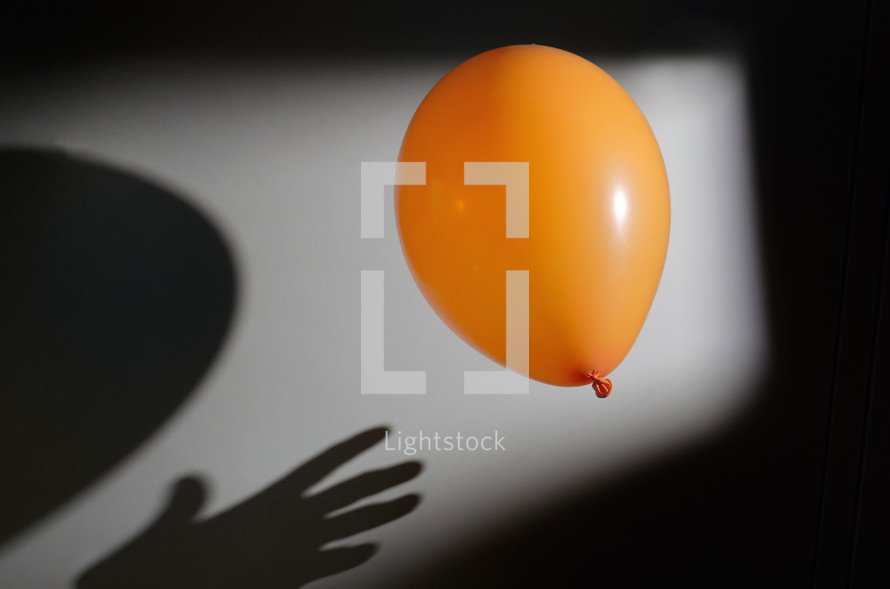 Abstract Orange Balloon With Shadow and Hand Shadow