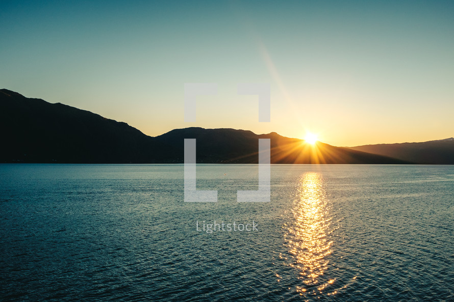 sunburst at sunset over a lake 
