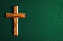 olive wood cross on a green background 