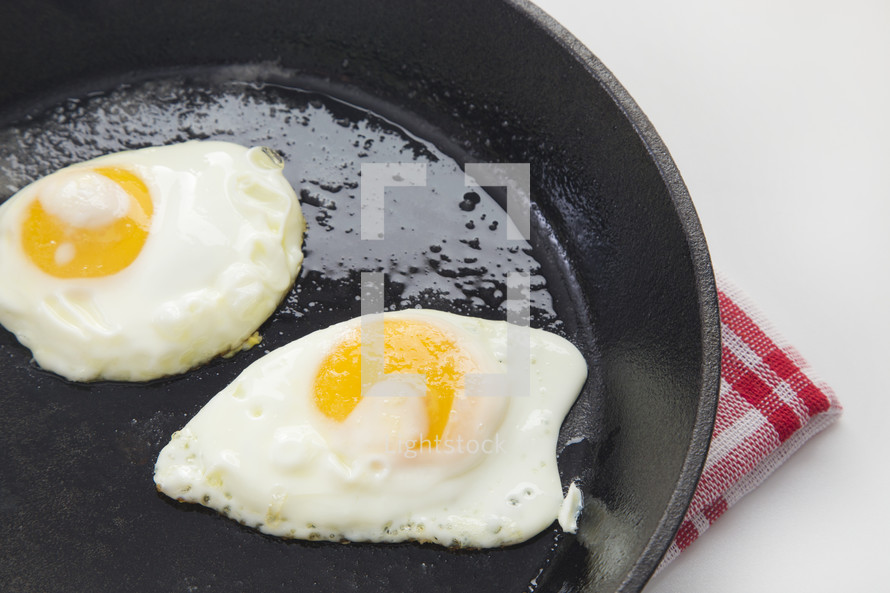 fried eggs in a cast iron skillet 