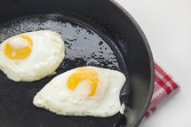 fried eggs in a cast iron skillet 
