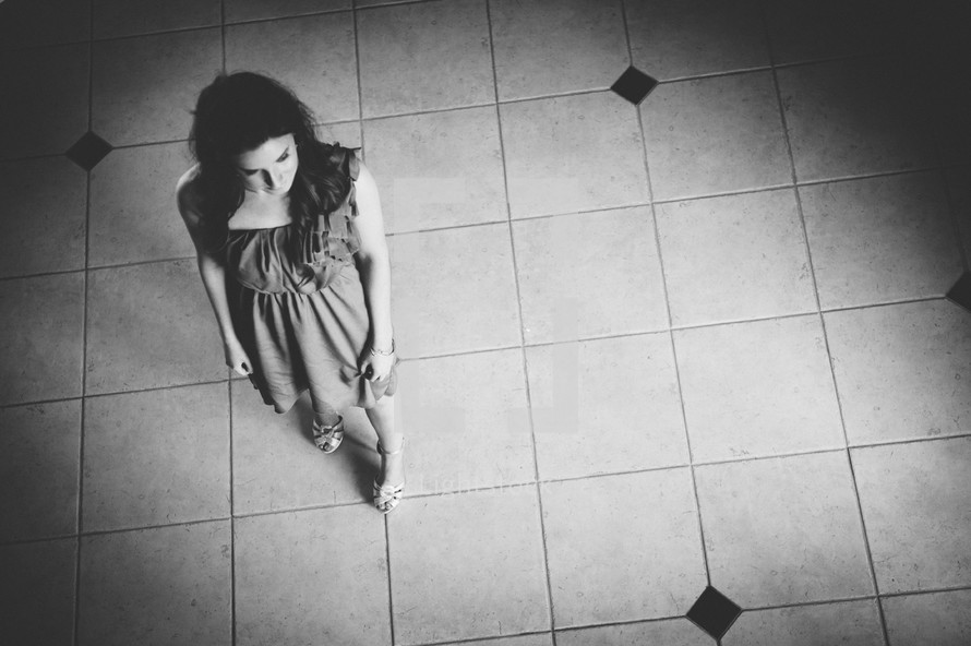 Downward view of a woman standing on a tile floor