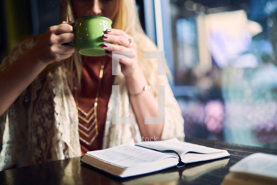 a woman drinking coffee and reading a Bible 