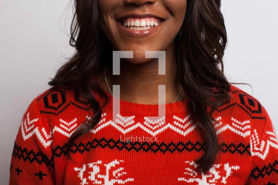 a smiling woman in a Christmas sweater 