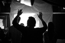 A man with hands raised in worship.
