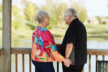 elderly couple standing together holding hands