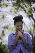 An African American woman with praying hands 