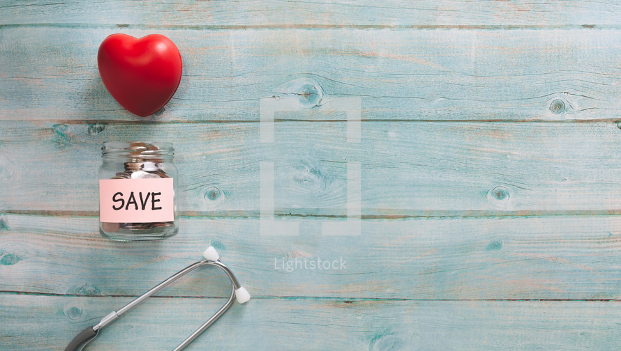 stethoscope and red heart with a savings jar 