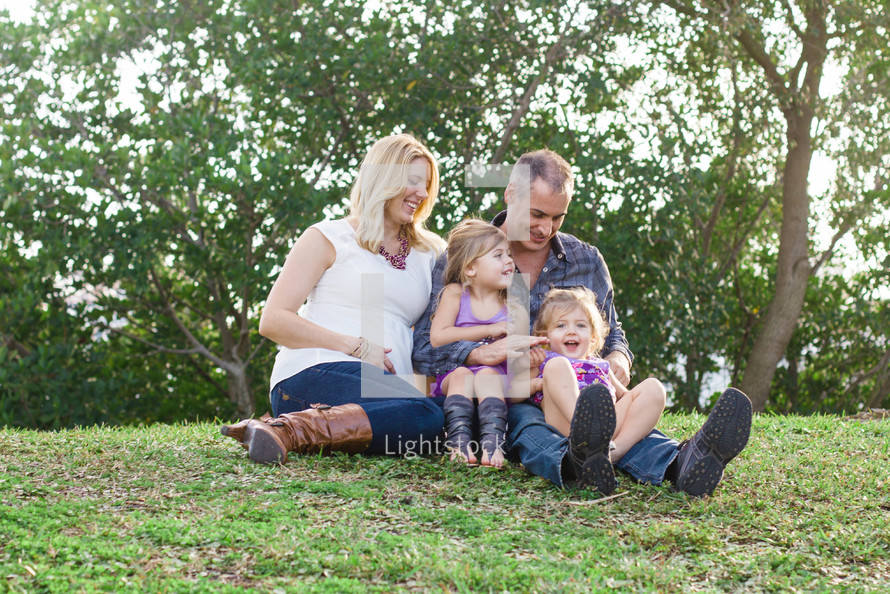 A family sitting together in the grass.