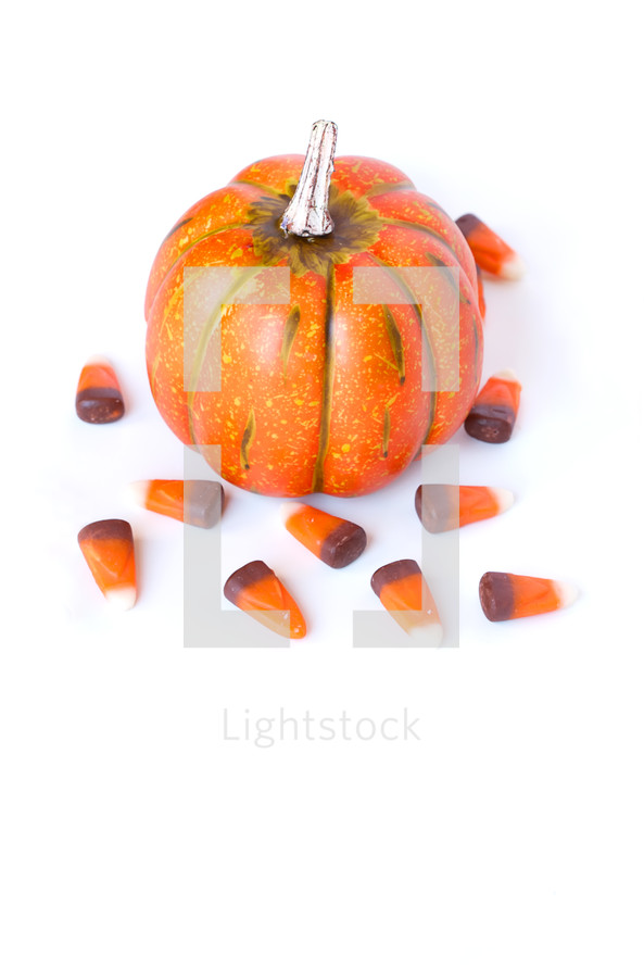 An orange pumpkin and candy corn.