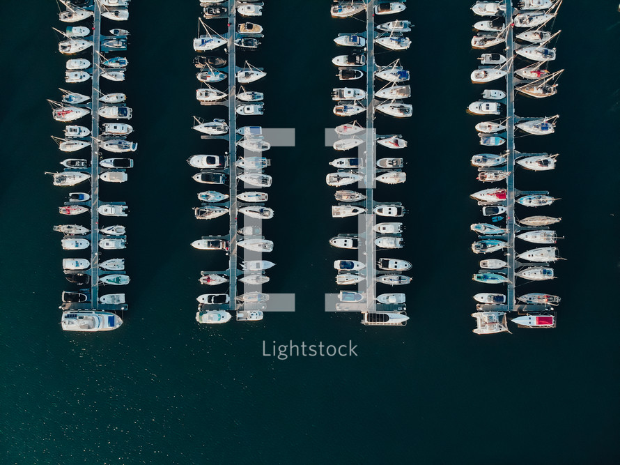 Drone photograph of boats and yachts moored at a marina, sailing and yacht mooring, blue water sea ocean photograph