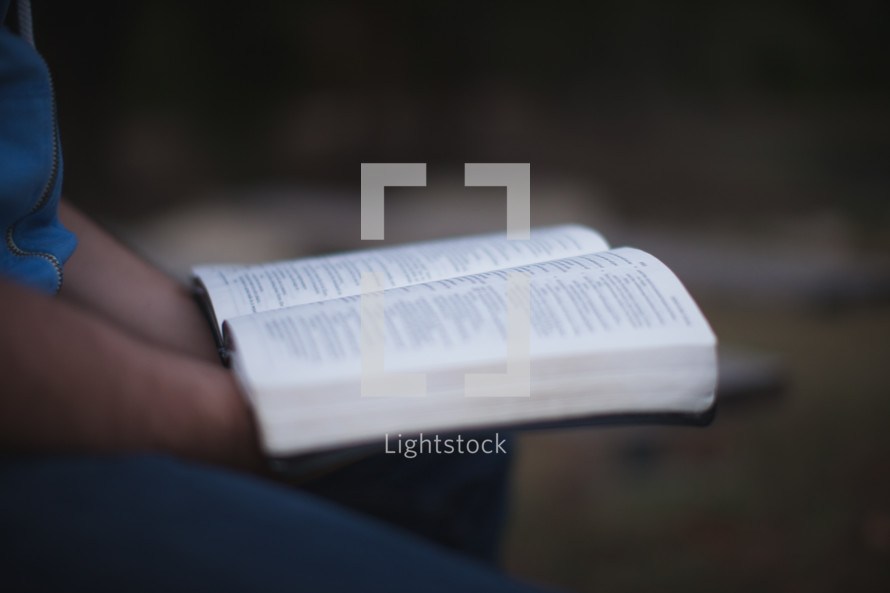 Holding an open Bible.